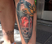 tatuaje en la pierna: calavera metida en un farol, con una mariposa